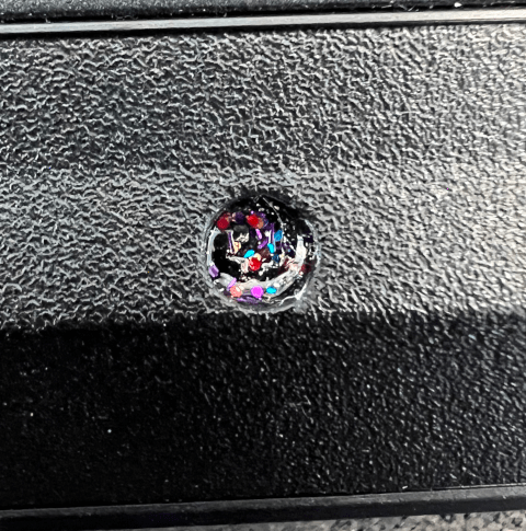 Photo of a screw that’s been covered with a unique pattern of (multi-color) glitter nail polish